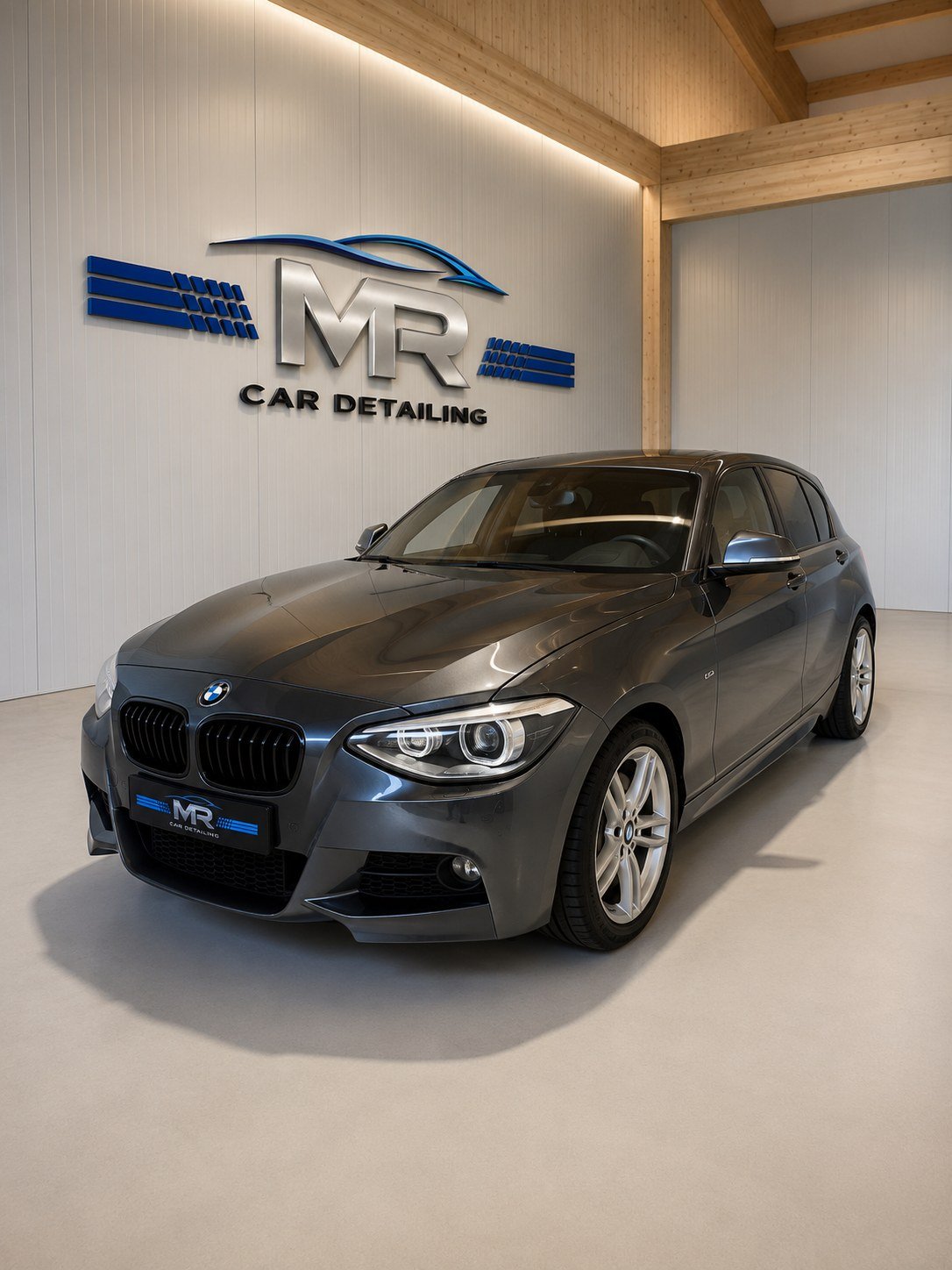 Aufbereiteter BMW 1er vor dem MR Car Detailing Logo im Showroom